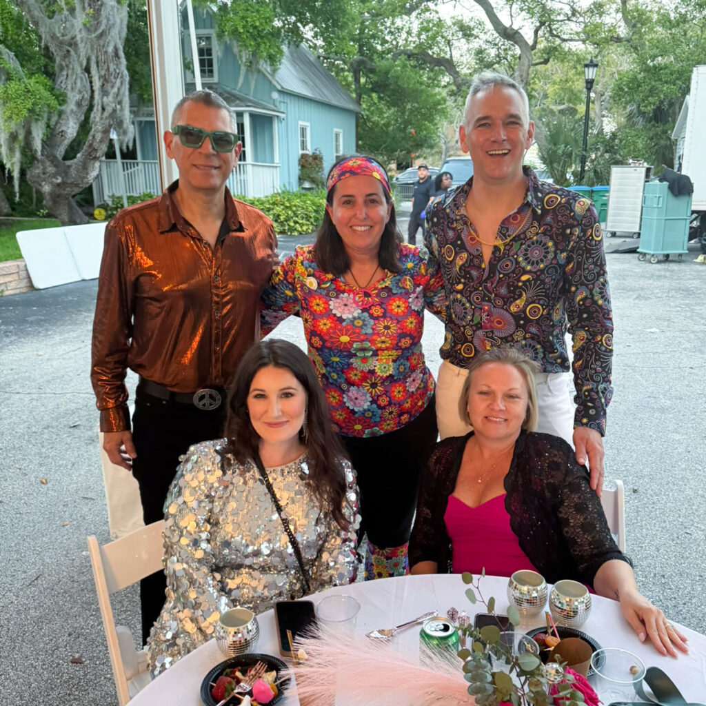 Group of team members at a table for the Ormond Memorial Art Museum Art in the Garden 2025 event.